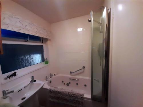 韋斯特貝的住宿－Chalet With Sea Views，带浴缸、水槽和淋浴的浴室