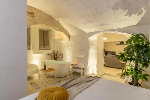 a bedroom with a tub and a bathroom with a kitchen at Bright Stone con Vasca Jacuzzi in Monopoli