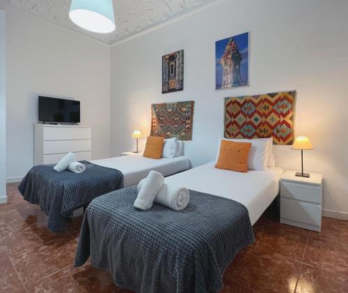 a bedroom with two beds and a flat screen tv at Stay U-nique Apartments Casanova in Barcelona