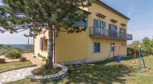a house with a tree and a swing at Villa Una Apartments in Labin