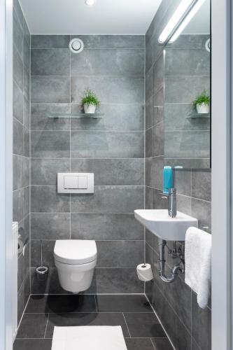 a bathroom with a toilet and a sink at Best Western Hotel am Europaplatz in Königsbrunn