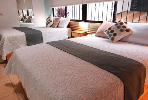 a hotel room with two beds and a window at Trebol Amarillo Bed & Breakfast in Escazu
