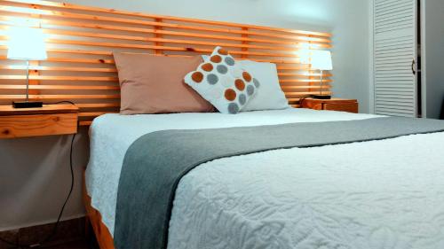 a bedroom with a large bed with two lamps at Trebol Amarillo Bed & Breakfast in Escazu