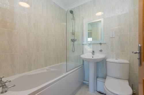 a bathroom with a toilet and a sink and a shower at Sand Dunes 6 The Manor in St Ives