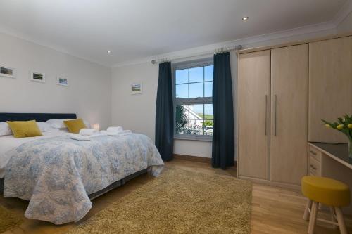 a bedroom with a bed and a large window at Sand Dunes 6 The Manor in St Ives