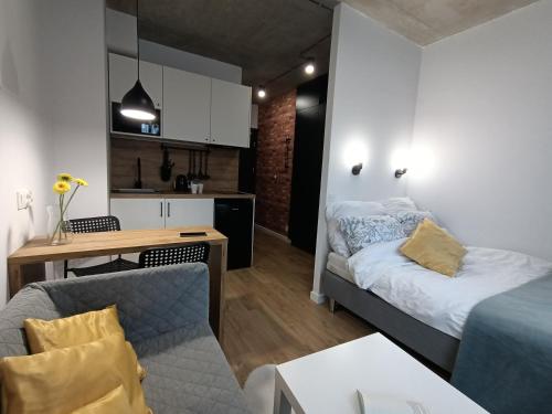 pequeña sala de estar con cama y cocina en Apartamenty Silver Place, en Szczecin