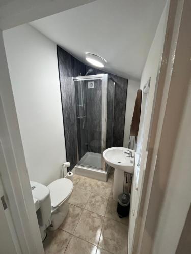 y baño con aseo, lavabo y ducha. en Corner Stone House - Apartment 2, en Great Yarmouth