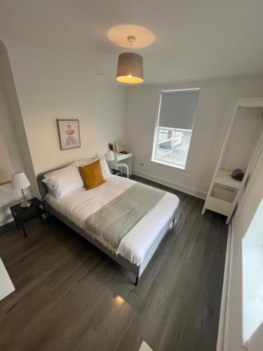 Un dormitorio con una cama grande y una ventana en Corner Stone House - Apartment 2 en Great Yarmouth