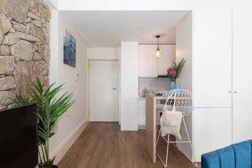 Il comprend un salon aux murs blancs et une cuisine avec une table. dans l'établissement Charm Luxury House, à Porto