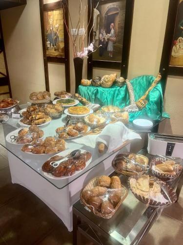 a table filled with lots of different types of pastries at Panacea Suites Hotel in Borg El Arab