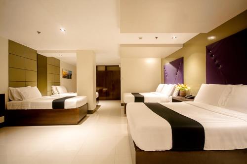 a hotel room with two beds with white and black sheets at ECL Resort Hotel Boracay in Boracay