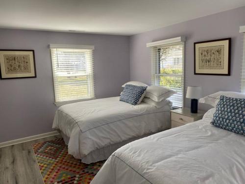 a bedroom with two beds and two windows at Newly Renovated Guest House in Oxford