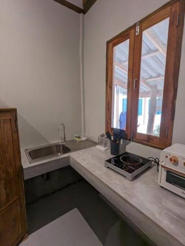 a kitchen with a sink and a stove and a window at Maison moderne proche du centre-ville in Luang Prabang
