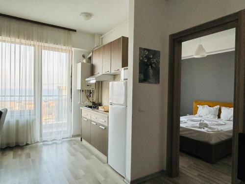 Zimmer mit einem Bett und einer Küche mit einem Kühlschrank. in der Unterkunft Apartament vedere la mare in Mamaia