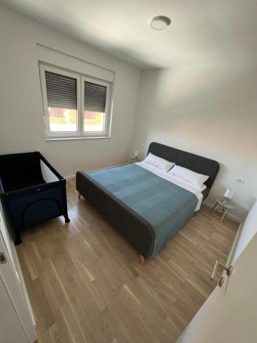 a bedroom with a large bed and a chair at Residence Doli in Vrsi