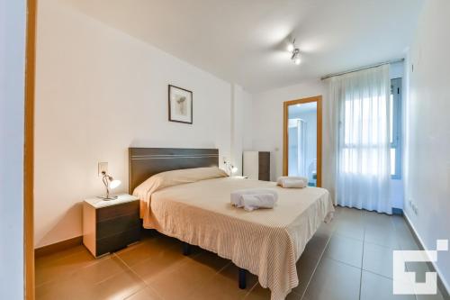 a bedroom with a large bed and a large window at Apartamento Borumbot 26 - Grupo Turis in Calpe