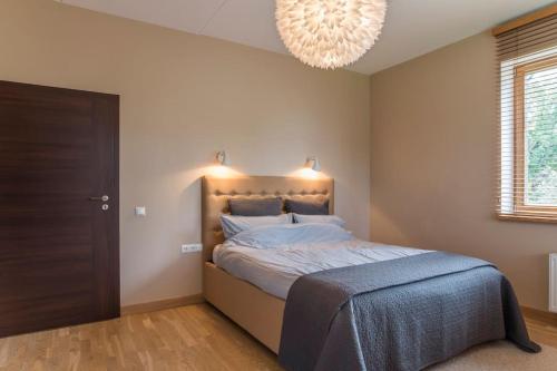 um quarto com uma cama grande e um lustre em STUNNING 2 BEDROOM APARTMENT IN QUITE PART OF RIGA em Riga