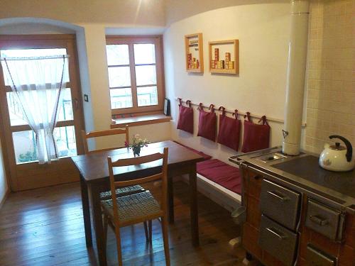eine Küche mit einem Tisch und ein Esszimmer mit einem Herd in der Unterkunft L'Abete Bianco Casa in montagna in Vezzano