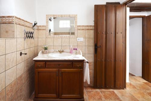 een badkamer met een wastafel en een spiegel bij Cortijo Salva in Periana