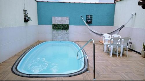 uma banheira de hidromassagem num quarto com uma mesa e cadeiras em Casa de temporada Guarapari Casa Dule em Guarapari