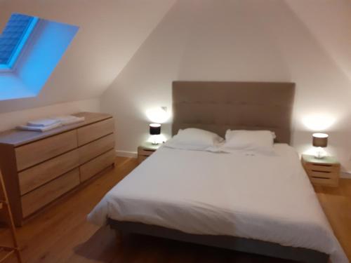 una camera con un letto bianco e due comodini di B&B - La Cense du Pont a Bachy