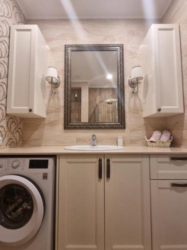 a bathroom with a sink and a washing machine at Luxury Stefan cel mare Apartment in Chişinău