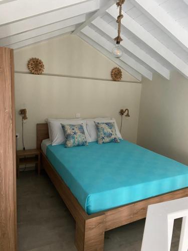 a bedroom with a large bed with blue sheets at Aleminas Rooms 1 in Symi