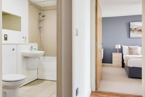 a bathroom with a toilet and a sink and a bed at Birmingham Skyline Apartment City Centre in Birmingham