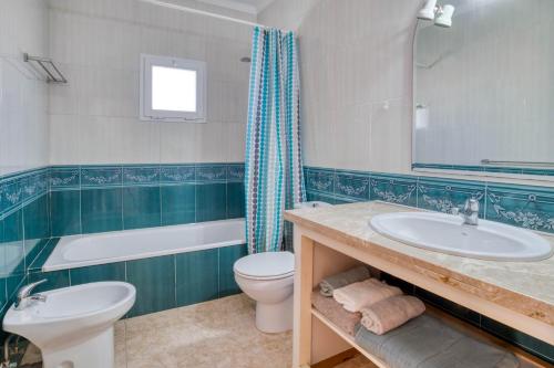 a bathroom with a sink and a tub and a toilet at Vela, casa con piscina privada a pocos metros de la playa in L'Escala