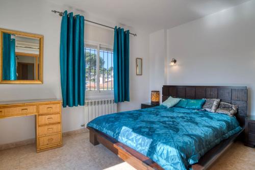 a bedroom with a bed and a dresser and a mirror at Vela, casa con piscina privada a pocos metros de la playa in L'Escala