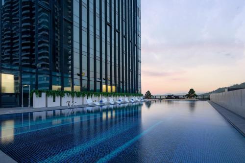a swimming pool in front of a tall building at Crowne Plaza Chaozhou Riverside, an IHG Hotel in Chaozhou