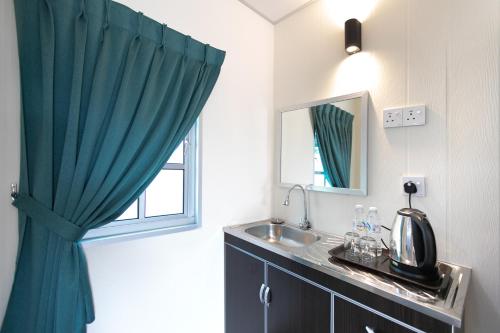 a bathroom with a sink and a window at Razo Mini Cabin House w/Bathroom 2pax BBQ in Butterworth