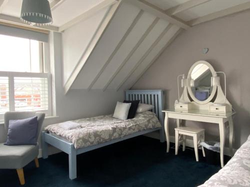 a bedroom with a bed and a mirror and a chair at Glengarth house Room only accommodation in Wells