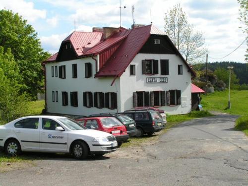 ein weißes Haus mit davor geparkt in der Unterkunft Chata Čert in Josefův Důl u Jablonce nad Nisou