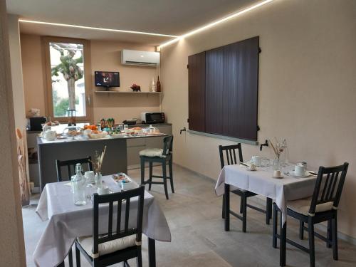 a dining room with tables and chairs and a kitchen at Montevecchi13 in Imola