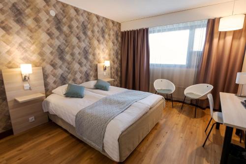 une chambre d'hôtel avec un lit, une table et des chaises dans l'établissement Hotel Kivitasku, à Kaarina