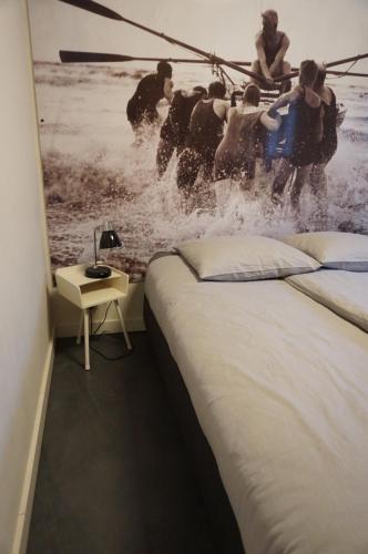 a bedroom with a bed and a group of people in the water at D'rommels Goed Slapen in Den Helder