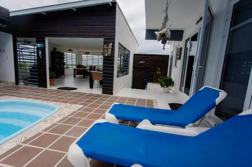 un patio con sillas azules y una piscina en Westpunt Beach Apartments, en Willemstad