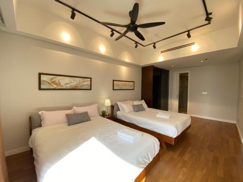 sypialnia z 2 łóżkami i wentylatorem sufitowym w obiekcie Anggun Residence Walking distance 5-10mins to Sogo Chow Kit Monorail and LRT station by Juststay w Kuala Lumpur
