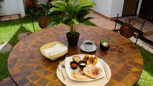 a table with a plate of food on it at Trebol Amarillo Bed & Breakfast in Escazu