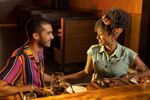 a man and a woman sitting at a table with wine glasses at Paradisus Grand Cana, All Suites - Punta Cana -All Inclusive in Punta Cana