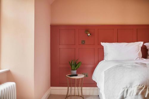 a bedroom with a red headboard and a bed at The Grandtully Hotel in Grandtully