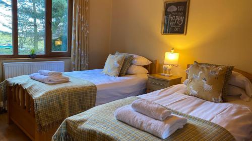 a bedroom with two beds with towels on them at Kingfisher Lodge with Hot Tub in Cupar