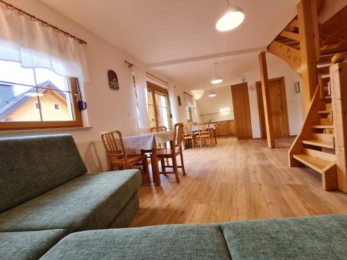 - un salon avec un canapé, une table et des chaises dans l'établissement Apartments Karmen, à Rateče