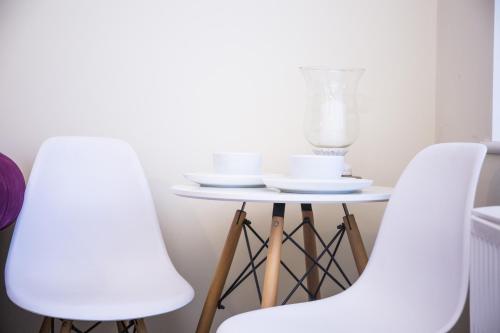 duas cadeiras brancas ao lado de uma pequena mesa com um liquidificador em 1-Bed Apartment - FREE Parking - Town Centre em Stratford-upon-Avon
