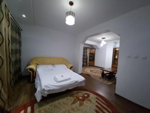 a bedroom with a bed and a living room at PENSIUNEA LUXURY in Vama