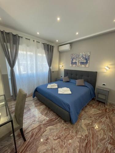 ein Schlafzimmer mit einem großen blauen Bett und einem Tisch in der Unterkunft Henry Suite in Rom