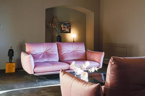 a living room with a pink couch and a table at Sa Suites in Trepuzzi