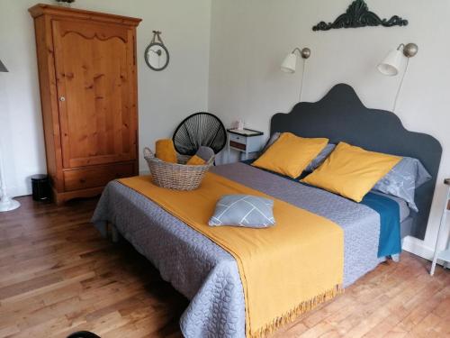 a bedroom with a bed with a basket on it at Mme Teurtroy, Chambres d'Hôtes La Prairie in Gouesnach