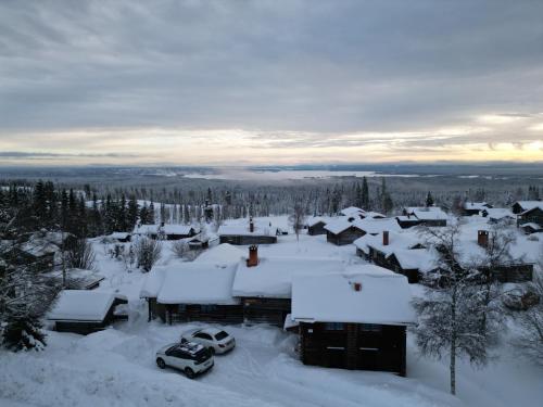 a small village covered in snow with cars parked at The Fryksås Chamber in Orsa